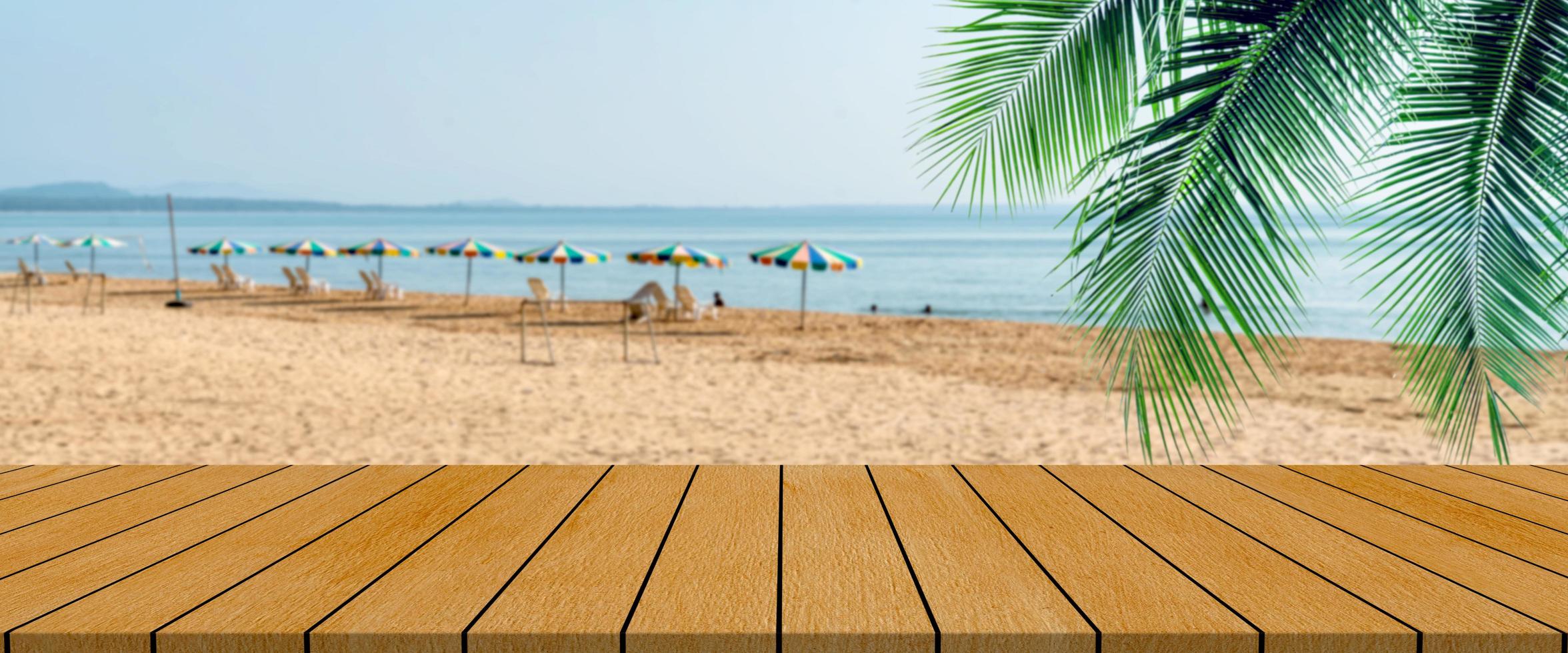 lange houten tafel met strandlandschap wazige achtergrond foto