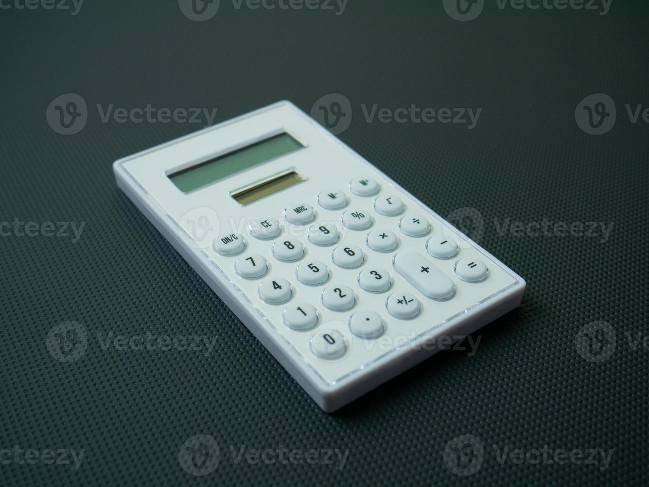 de witte rekenmachine op zwarte achtergrond voor zakelijke inhoud. foto