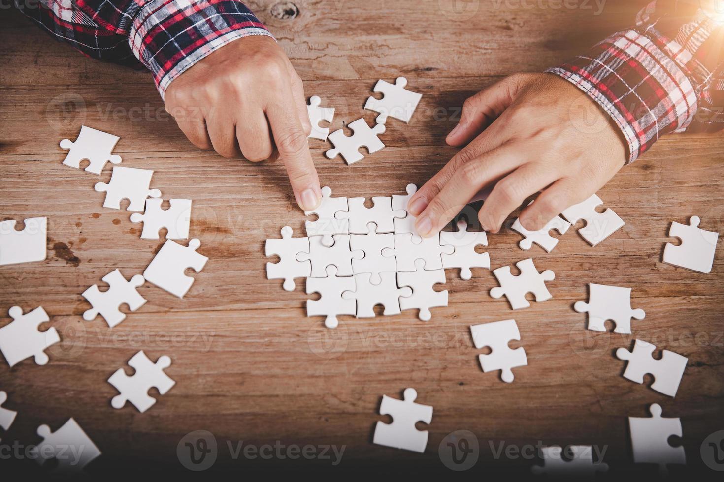 handen met puzzelstuk op houten tafel achtergrond, succes business, oplossingsstrategie, teamwork partnerschap concept foto