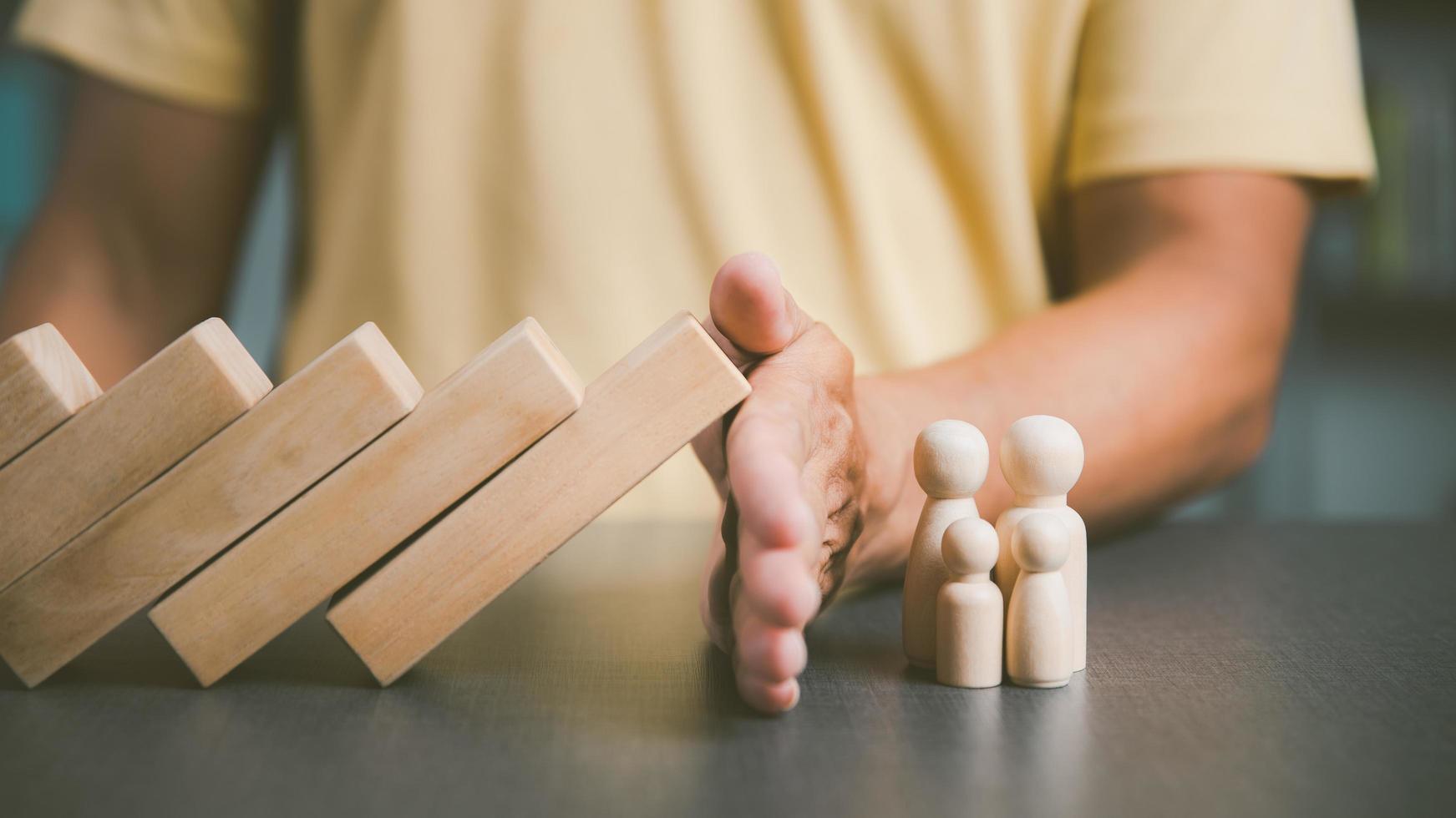 vader blokkeerde het houten blok met zijn hand om bescherming voor het gezin te tonen. en ondersteuning en hulp met advies het concept van familierelaties die zullen verbinden met veiligheid liefde en mededogen foto