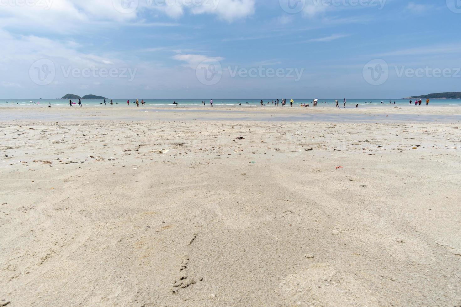mensen nemen een duik in de zee en wandelen over het witte zand. foto