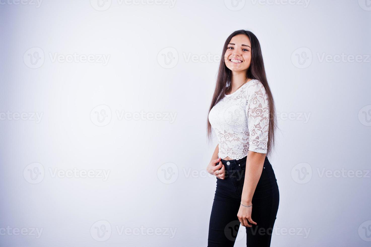 portret van een elegante jonge vrouw in witte top en zwarte broek in de studio. foto