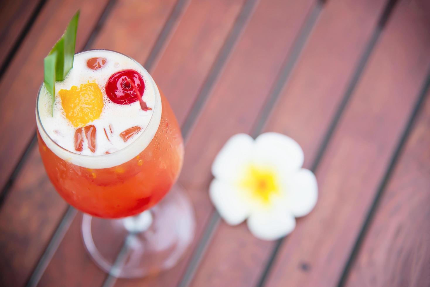 cocktailrecept naam mai tai of mai thai wereldwijde gunstcocktail inclusief rum limoensap orgeatsiroop en sinaasappellikeur - zoete alcoholische drank met bloem in de tuin ontspannen vakantieconcept foto