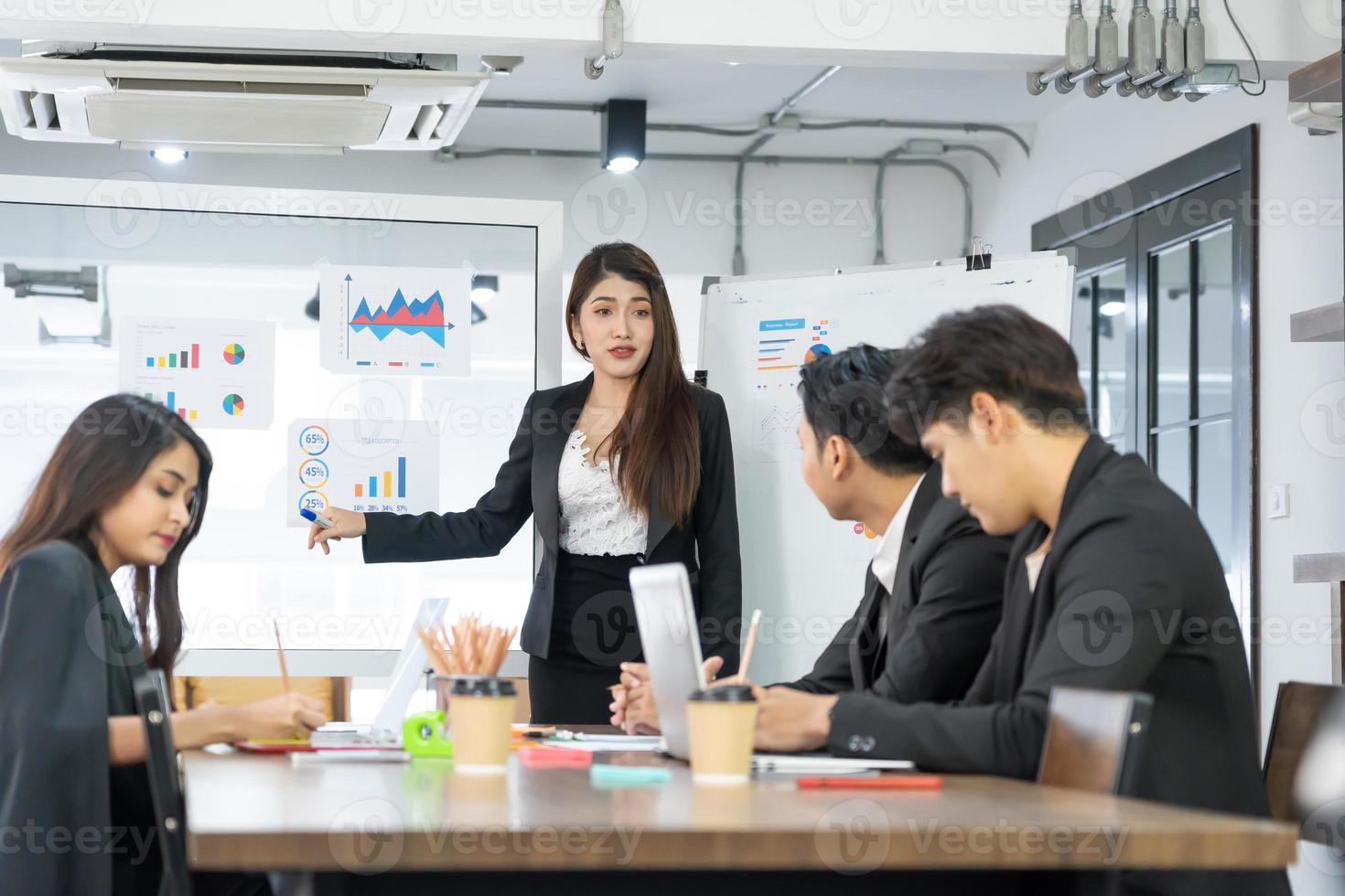 mooie zakenvrouw geeft verslag, presentatie aan haar zakelijke collega's in de vergaderruimte, ze toont afbeeldingen. succesvolle vrouwelijke zakelijke professional. foto