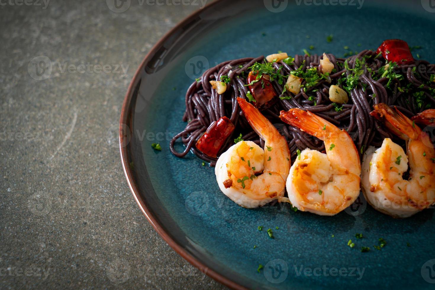 gewokte zwarte spaghetti met knoflook en garnalen foto