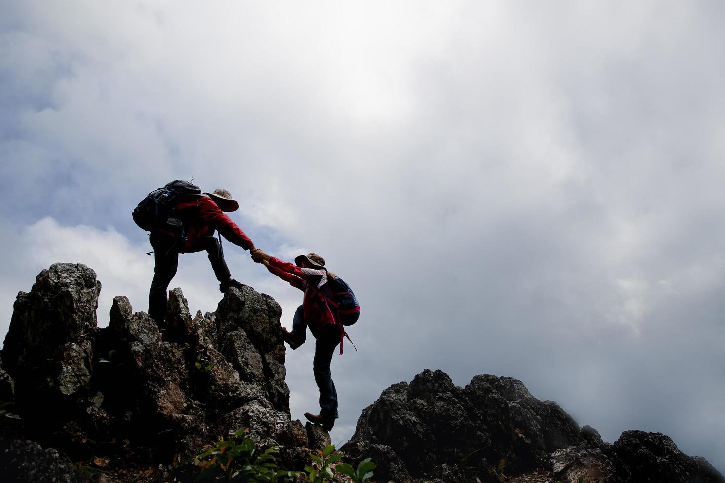 persoon wandelen vrienden elkaar helpen een berg op. man en vrouw die een helpende hand bieden en een actieve, fitte levensstijl. Azië paar wandelen helpen elkaar. concept van vriendschap, teamwork. foto