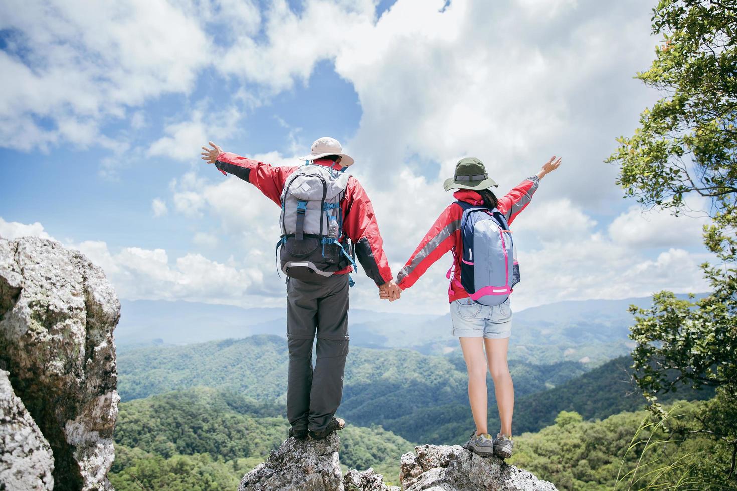 jonge toeristische paar kijken naar een spectaculair berglandschap in de hoge bergen. man en vrouw wandelaar op de bovenste rots. een paar verliefde reizigers. mensen begroeten de dageraad. geliefden reizen. kopieer ruimte foto