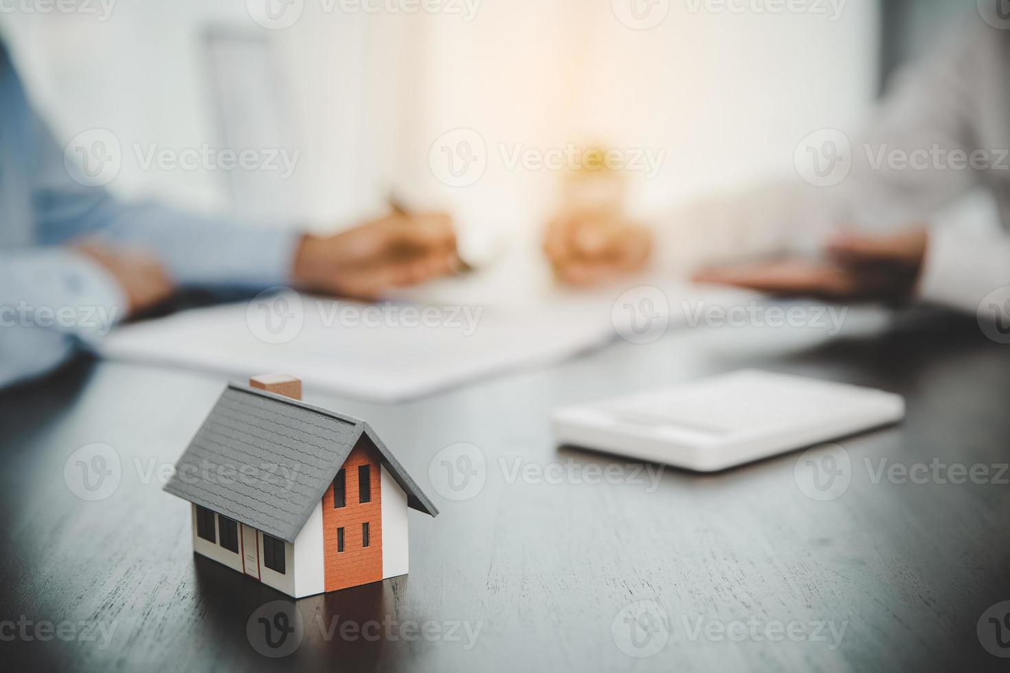 makelaar adviseur die een cliënt raadpleegt. makelaar biedt hand voor klant teken overeenkomst contract handtekening voor koop of verkoop huis. zakelijk hypotheekconcept en huisverzekering foto