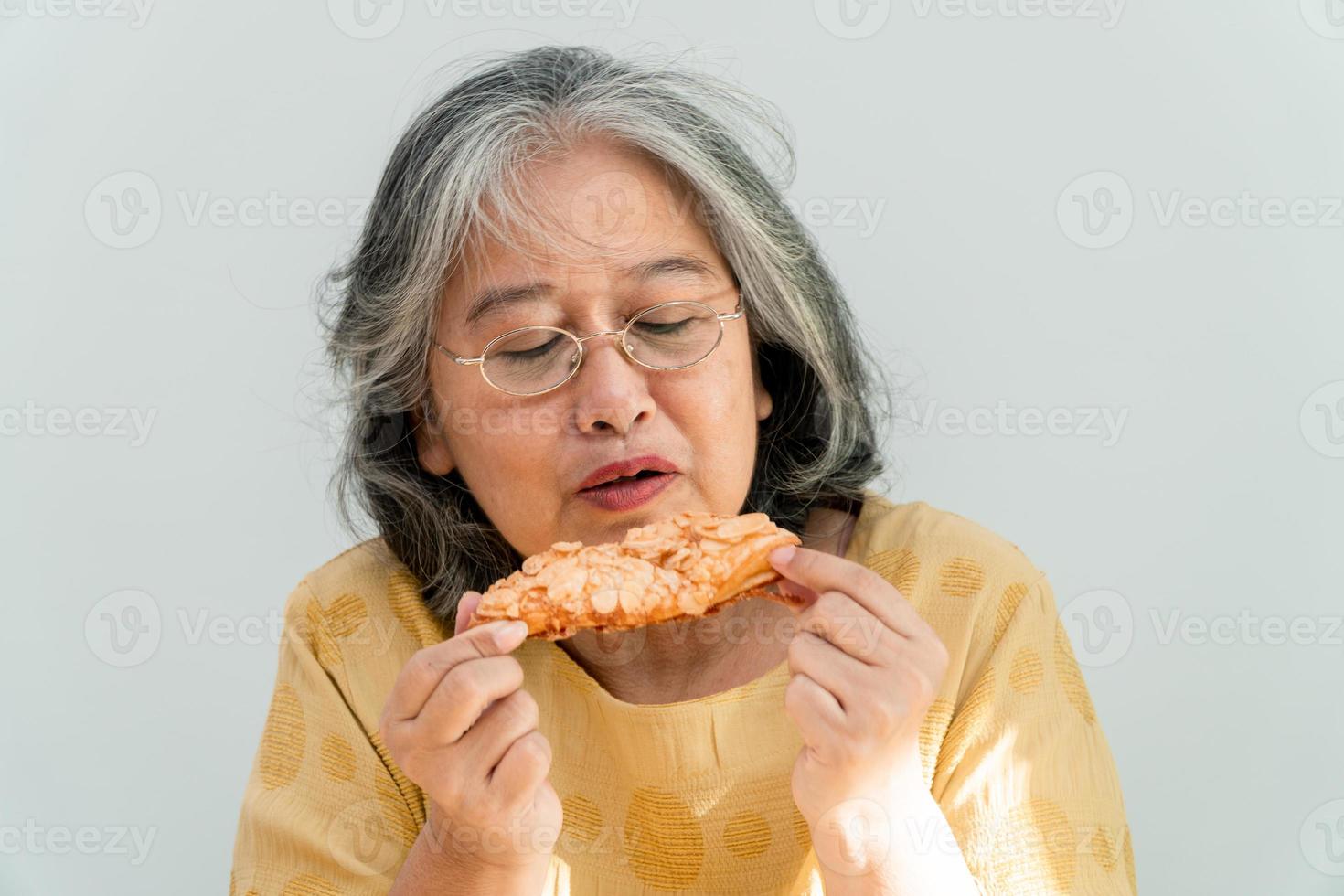 gelukkige Aziatische senior vrouwen genieten van het eten van taart foto