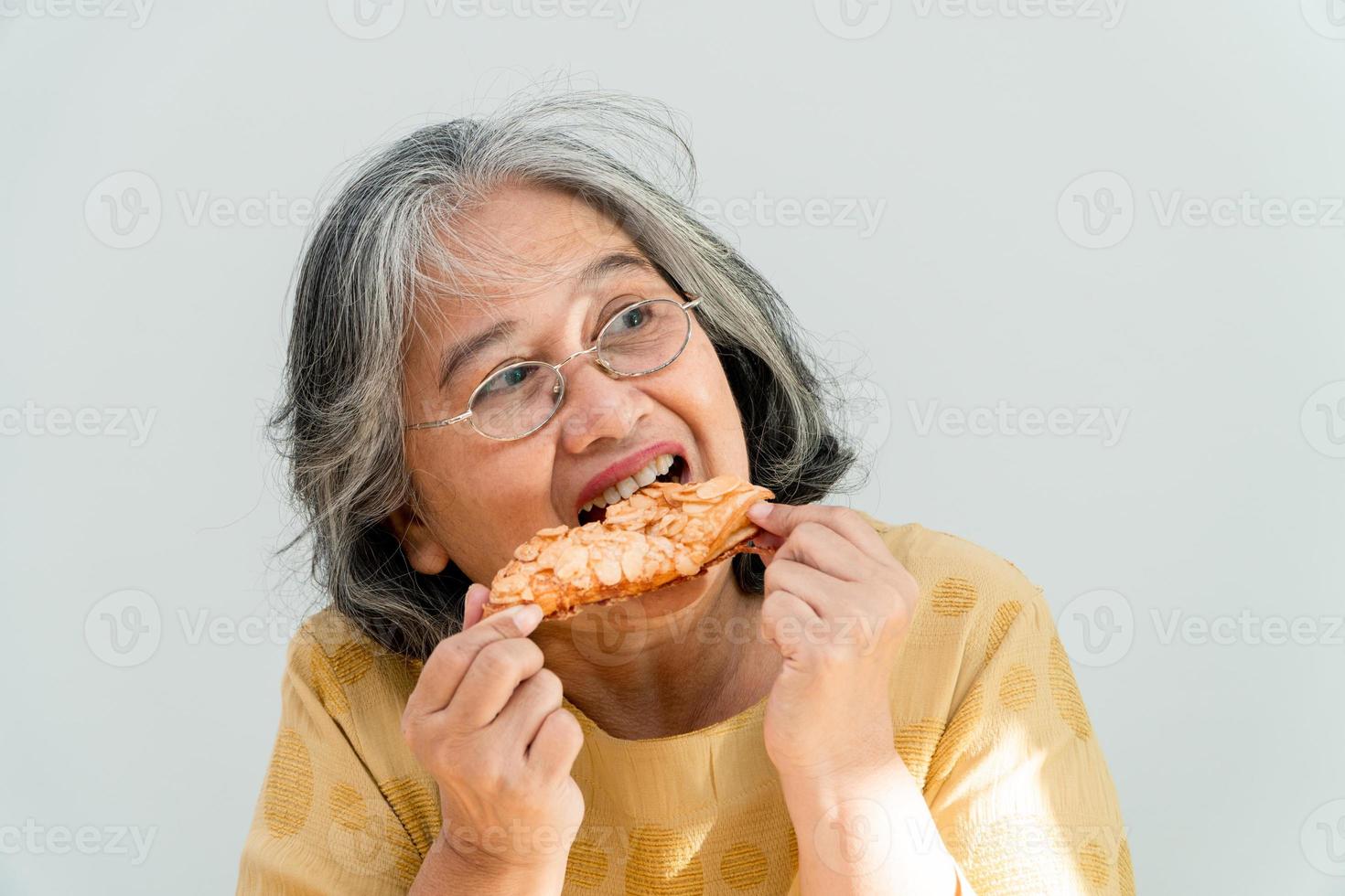 gelukkige Aziatische senior vrouwen genieten van het eten van taart foto