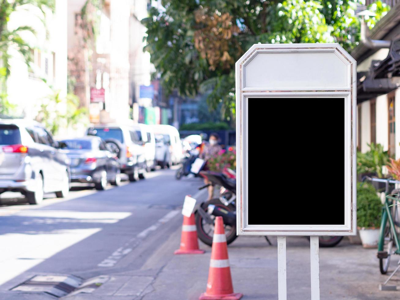leeg zwart reclamebord met witte frameadvertentie die verticaal aan de kant van de weg ligt foto
