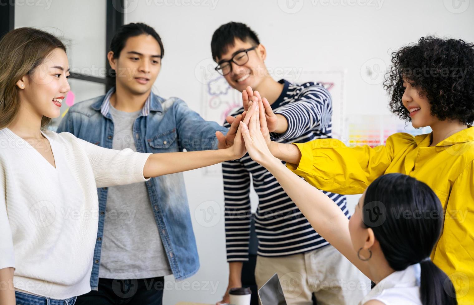 groep aziatische team creatieve zakenmensen slaan handen ineen partnerschap teamwork concept foto
