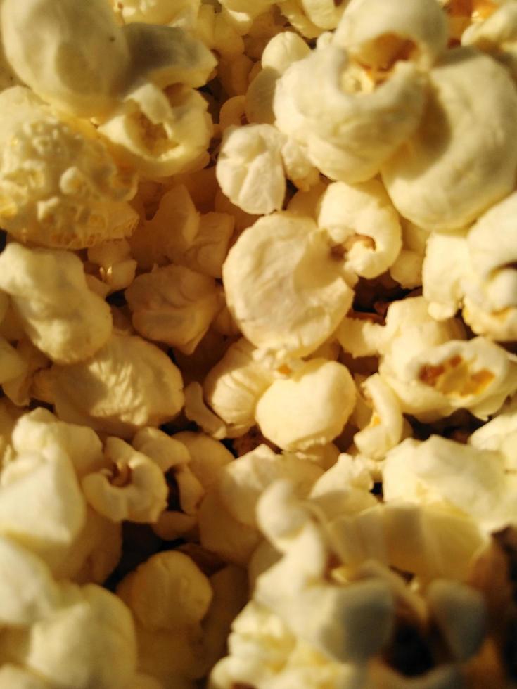 hoog zicht op rijpe popcorn geserveerd in groene bowl.close up. Naast het helpen van je afvallen, heeft het eten van popcorn ook andere gezondheidsvoordelen. foto