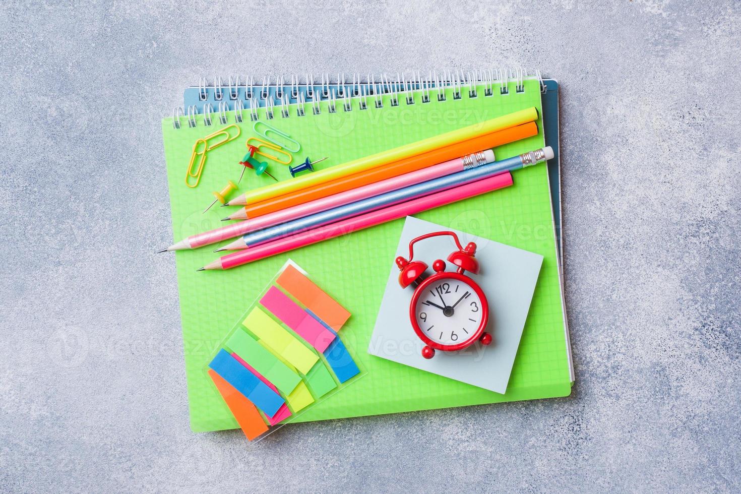 schoolbenodigdheden, notebooks potloden op grijze achtergrond met kopie ruimte. foto