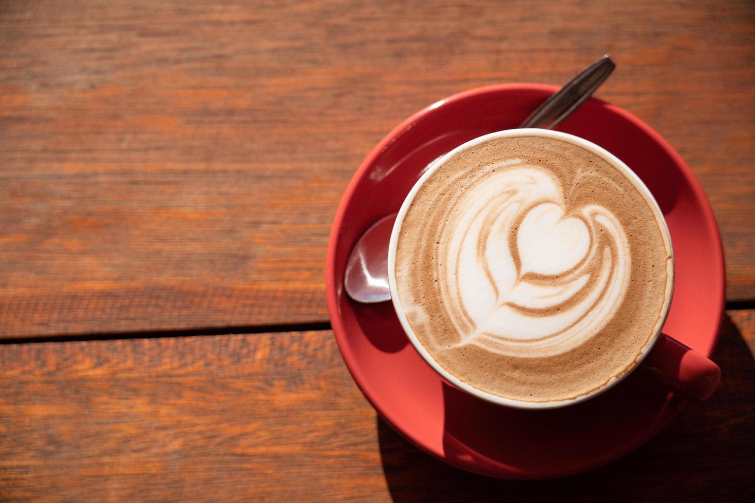 bovenaanzicht van warme mokka latte art op houten tafel. foto