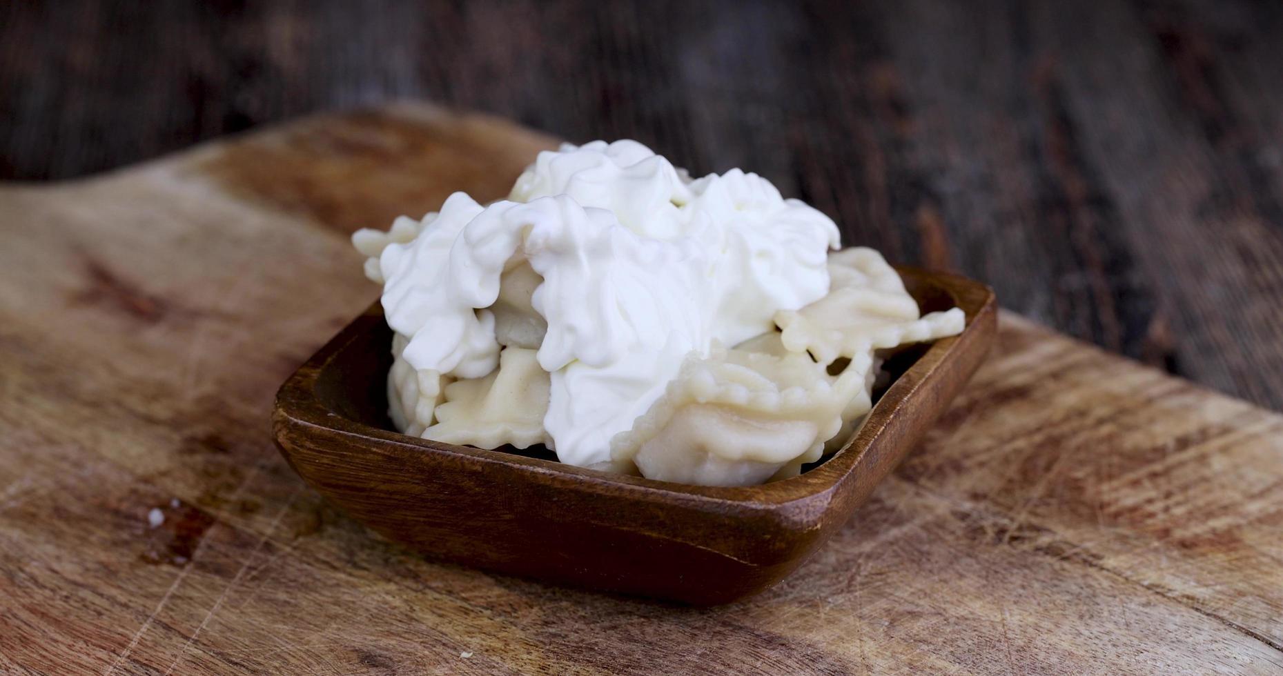 neem dumplings met zure room met een vork tijdens een maaltijd foto