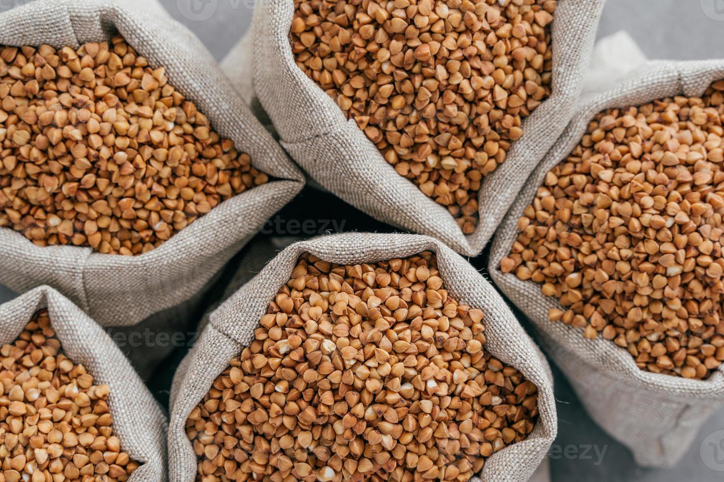 kleine linnen zakjes gevuld met rauwe boekweit voor je gezonde voeding. landbouw en landbouw. ongekookte boekweit. dieetproduct foto