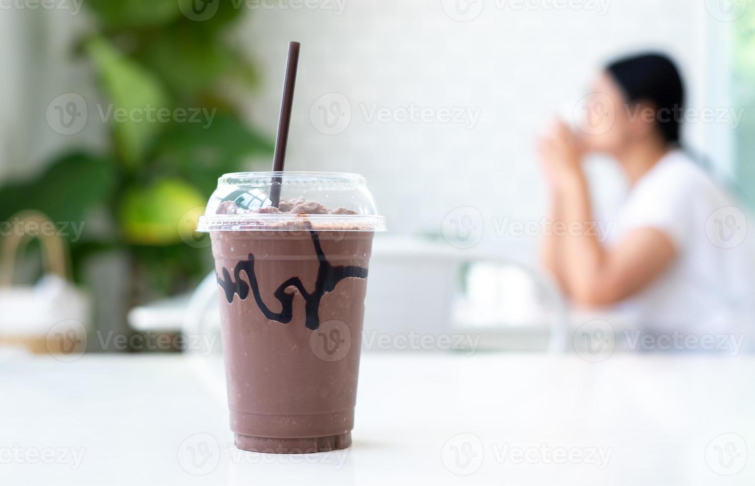 coco, ijskoude chocolade in de beker op witte tafel in coffeeshop, concept eten, drinken en gezondheid, kopieer ruimte foto