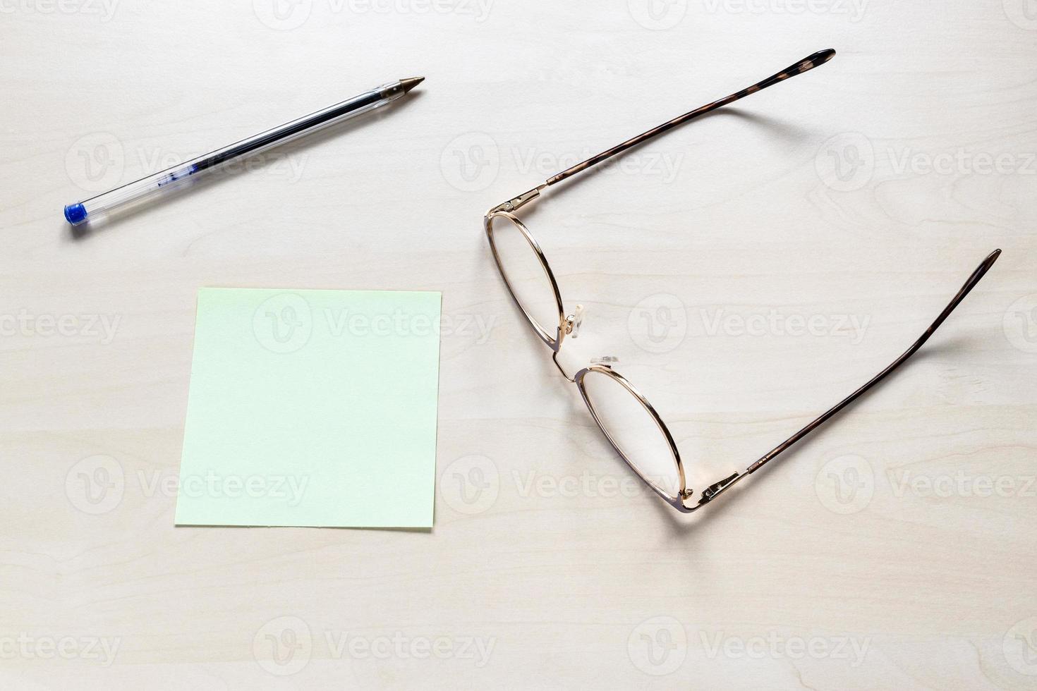 bril, pen op blanco groen vel notitiepapier foto