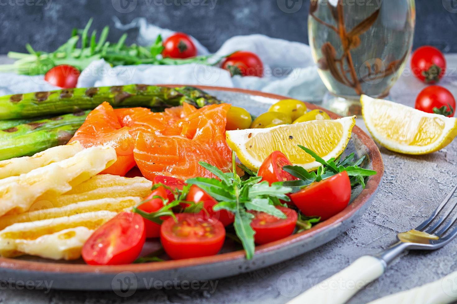 salade met asperges, gegrilde halloumi kaas, zalmfilet, tomaten, rucola en groene olijven foto