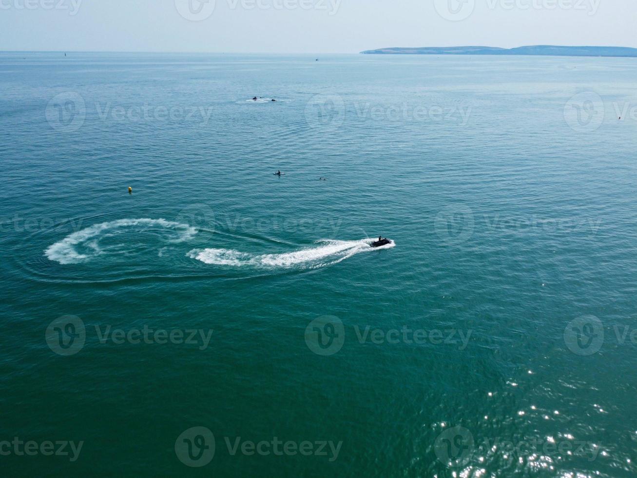 hoge hoekbeelden en luchtfoto van de oceaan met hogesnelheidsboten, mensen hebben plezier en genieten van het heetste weer op de strandboulevard van bournemouth in engeland uk. foto