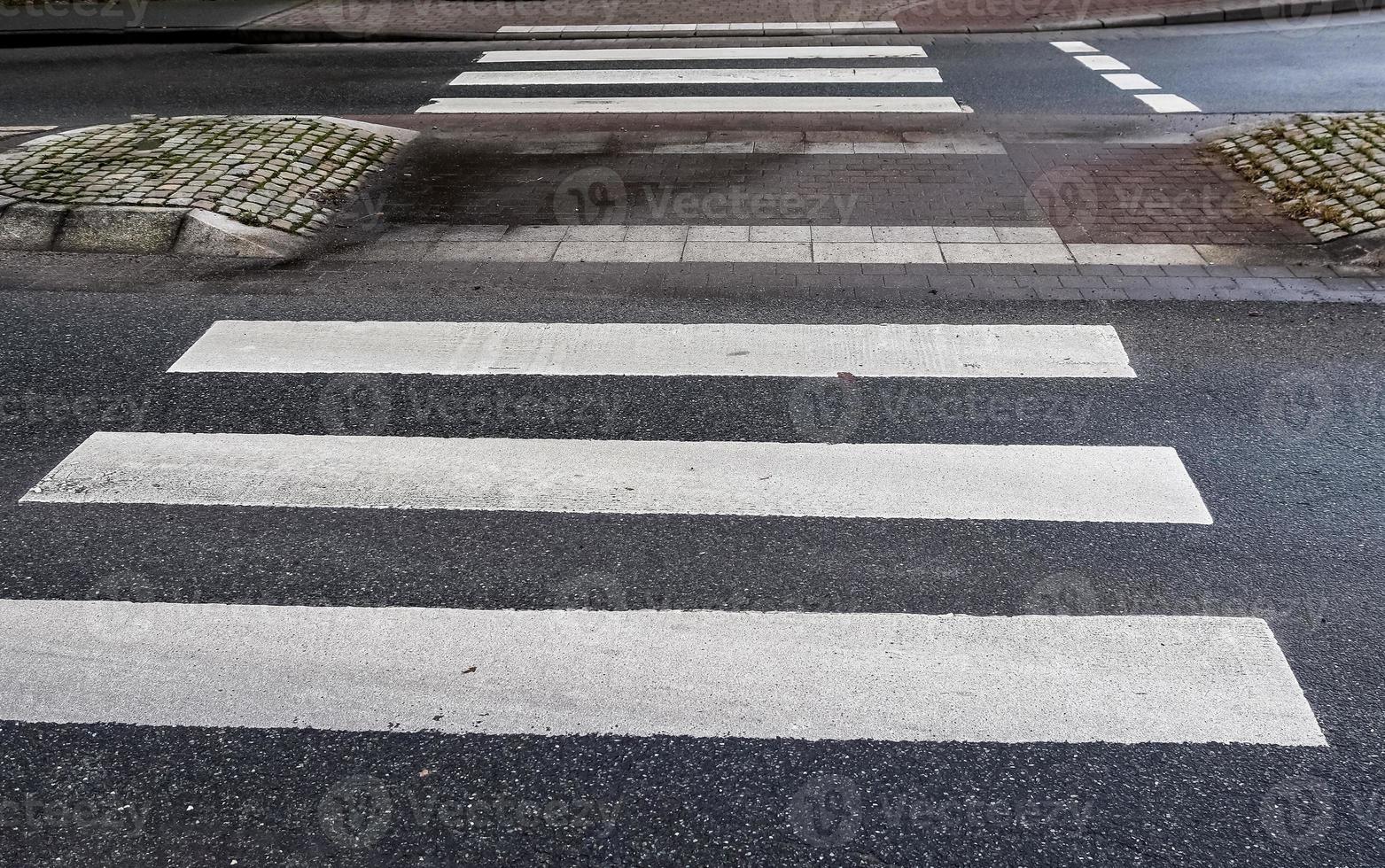 wit geschilderde zebrapad voor voetgangers op een weg in europa. foto