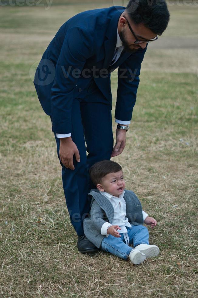 Aziatische Pakistaanse vader houdt zijn 11 maanden oude baby vast in het plaatselijke park foto