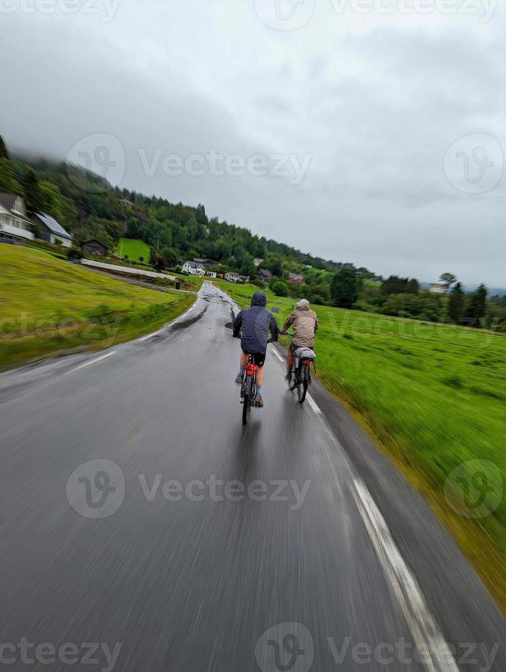 twee fietsende mannelijke toeristen die zich snel voortbewegen op de Noorse fjorden kustweg 7 foto