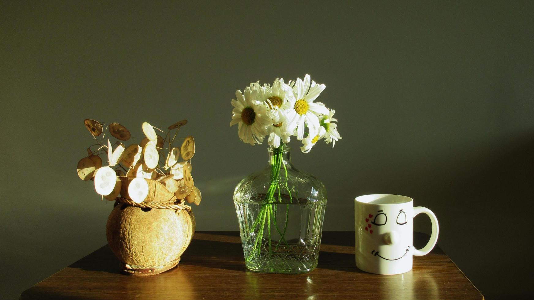 bloemenvazen en kopje met lachend gezicht, woondecoratie foto