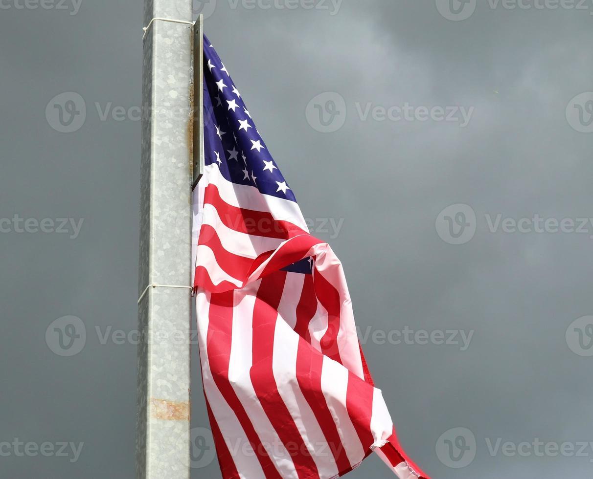 Amerikaanse vlag aan een vlaggenmast die langzaam in de wind tegen de lucht beweegt foto