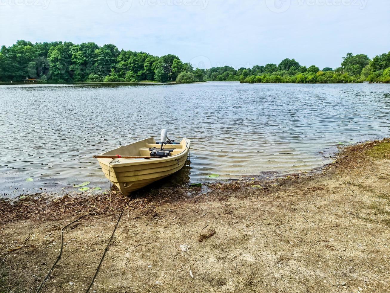 roeiboot liggend aan de kust van een meer op een zonnige dag foto