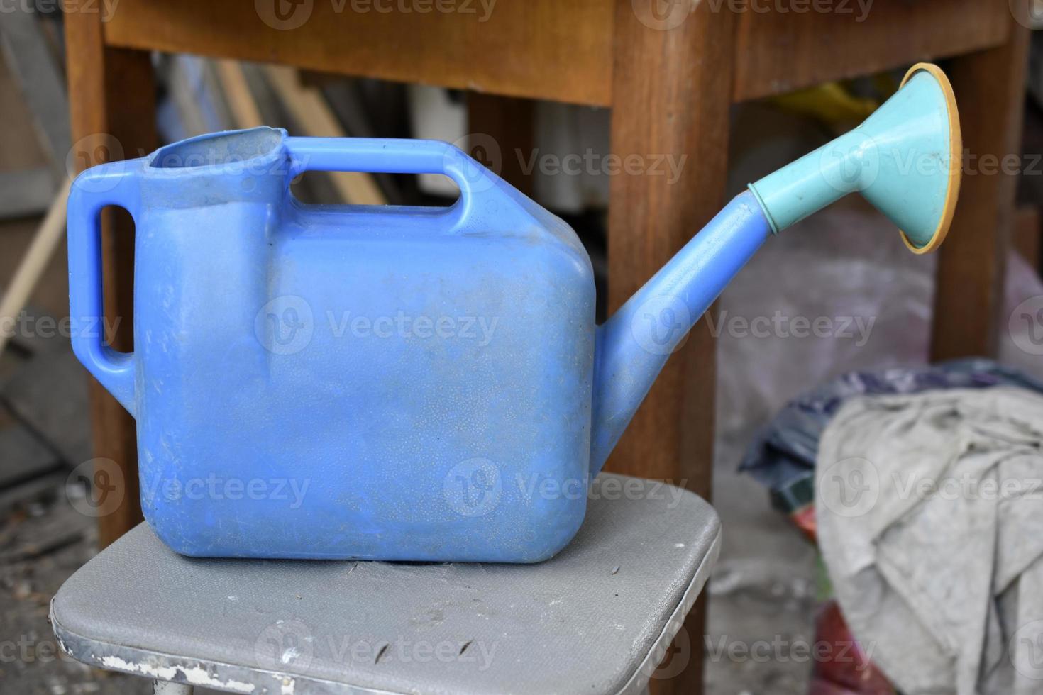 blauwe tuingieter voor het bewateren van tuinplanten in de zomer. tuingereedschap close-up. foto