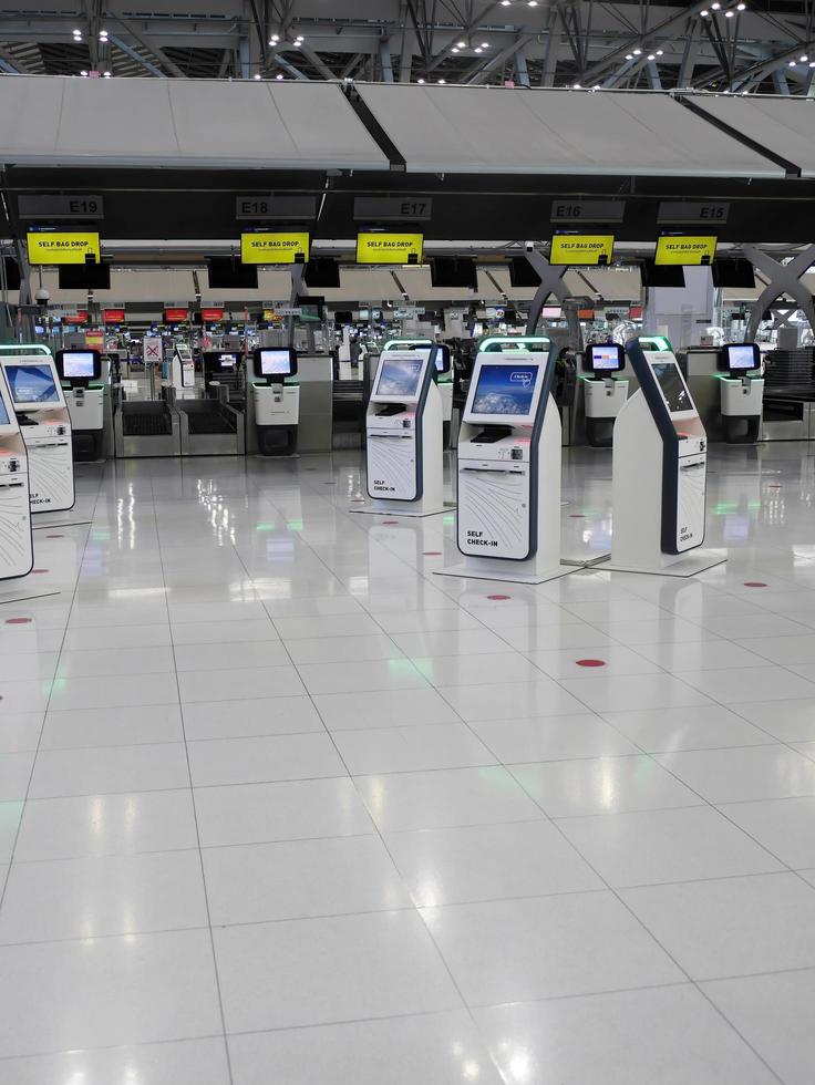 zelf inchecken machinehal en helpdeskkiosk op luchthaven voor inchecken, instapkaart afdrukken of ticket kopen, internationale luchthaven van bangkok, thailand foto