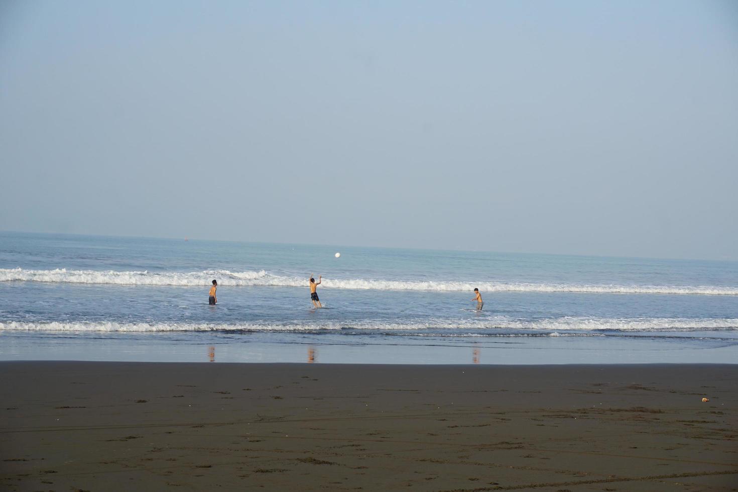 bal spelen op het strand op vakantie foto