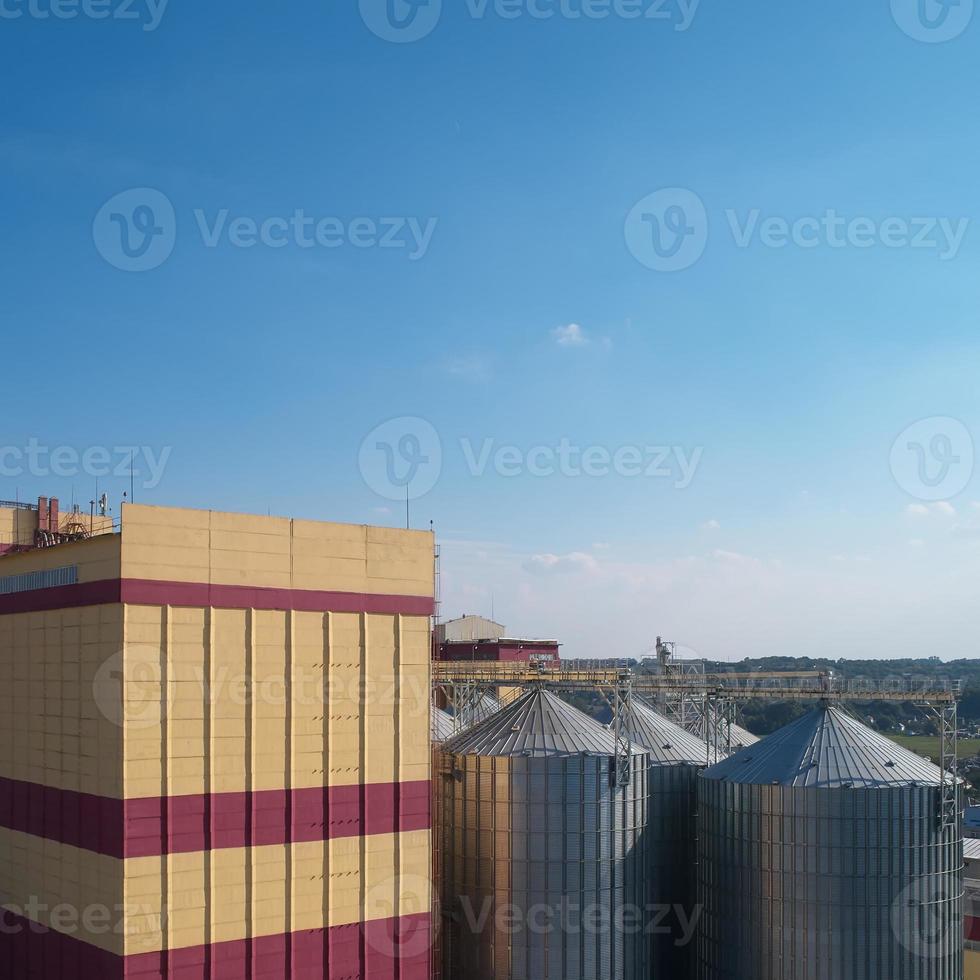 landbouw silo. opslag en drogen van granen, tarwe, maïs, soja, tegen de blauwe lucht met wolken. foto