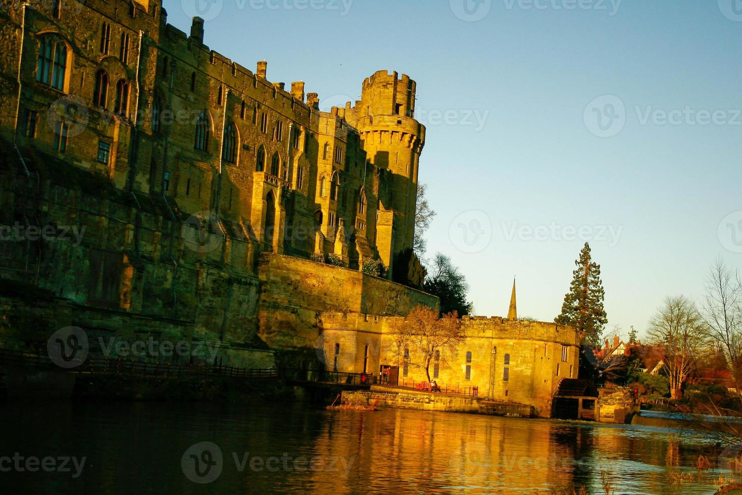 oud europees middeleeuws architectonisch gebouw kasteel in gouden herfstlicht met de blauwe hemelachtergrond in de herfst foto