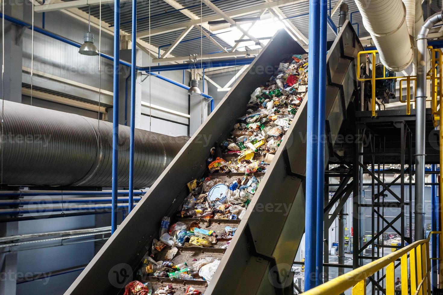 bewegende transportband op moderne afvalverwerkingsfabriek. gescheiden en sorteren van afvalinzameling. recycling en opslag van afval voor verdere verwijdering. foto