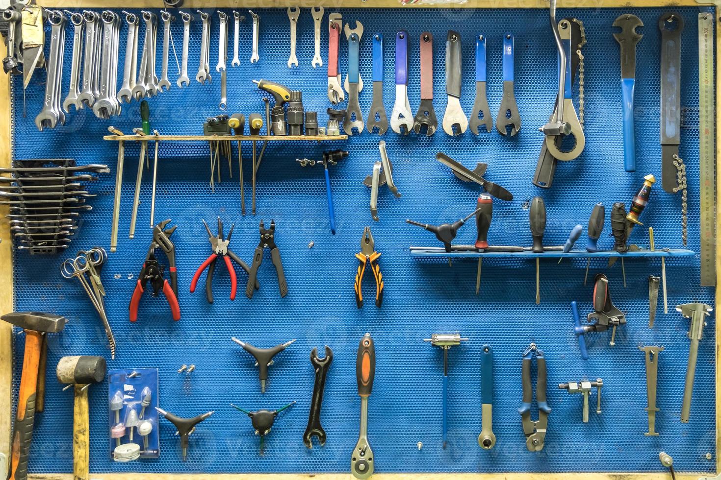 set reparatiehulpmiddelen in een moderne fiets- en autoreparatiewerkplaats op een blauwe achtergrond foto