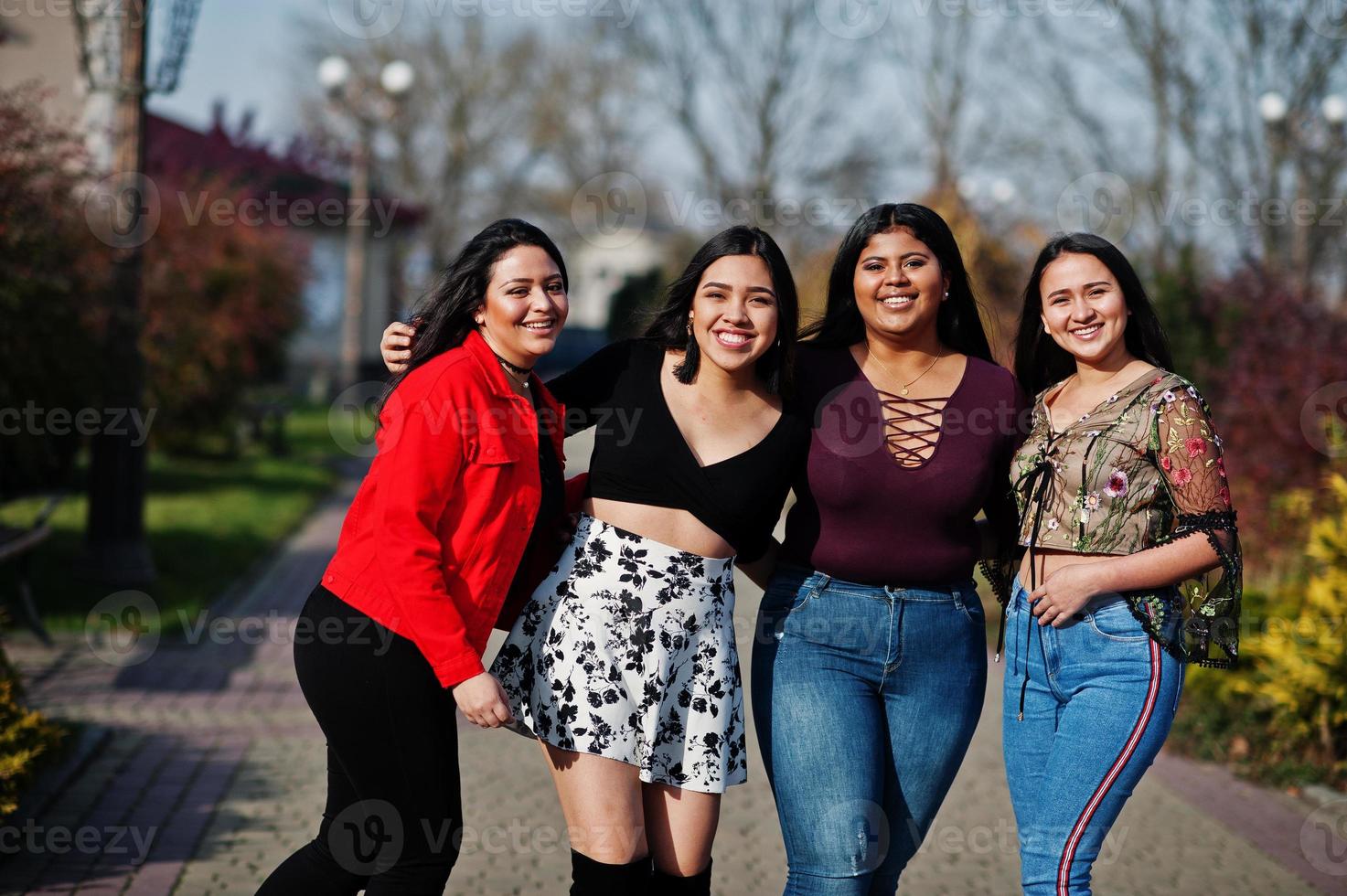 groep van vier gelukkige en mooie latino-meisjes uit ecuador poseerden op straat. foto