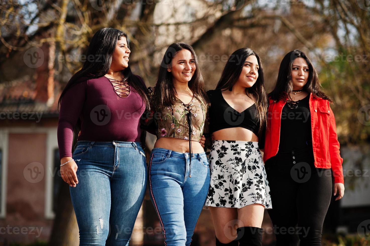 groep van vier gelukkige en mooie latino-meisjes uit ecuador poseerden op straat. foto