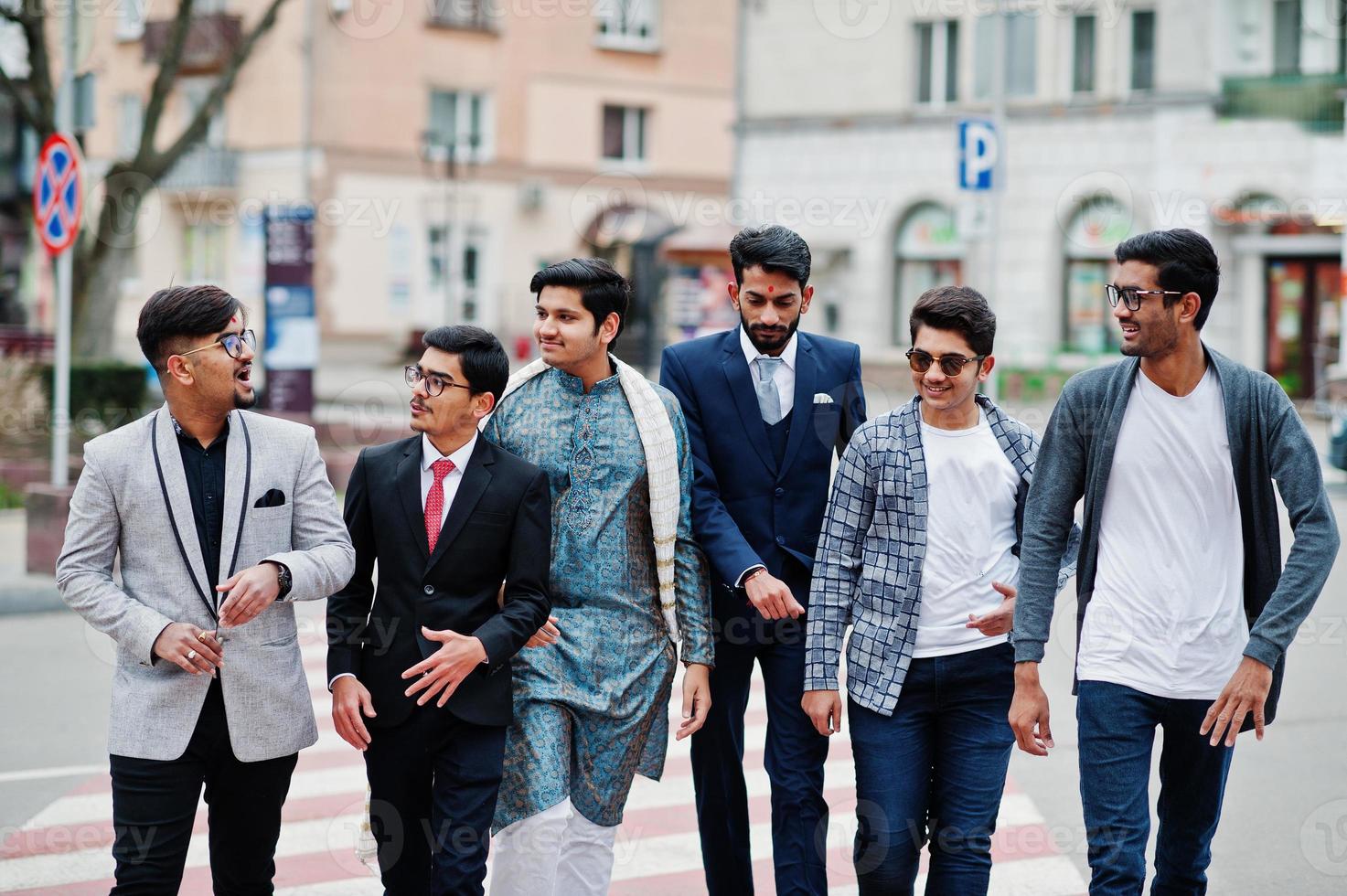 groep van zes Zuid-Aziatische indiaan mans in traditionele, casual en zakelijke kleding die samen op zebrapad lopen. foto