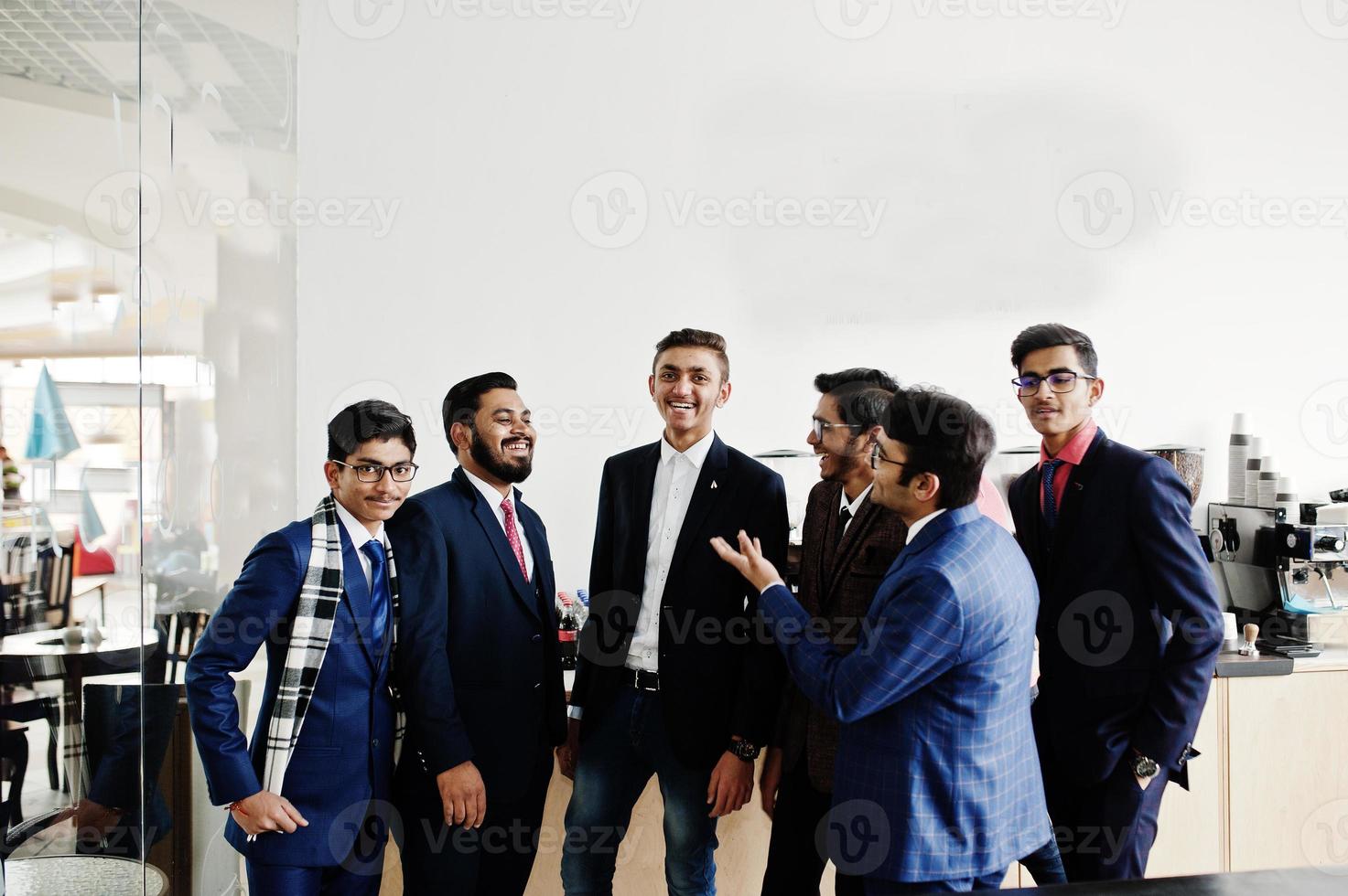 groep van zes Indiase zakenman in pakken die op café staat en iets bespreekt. foto