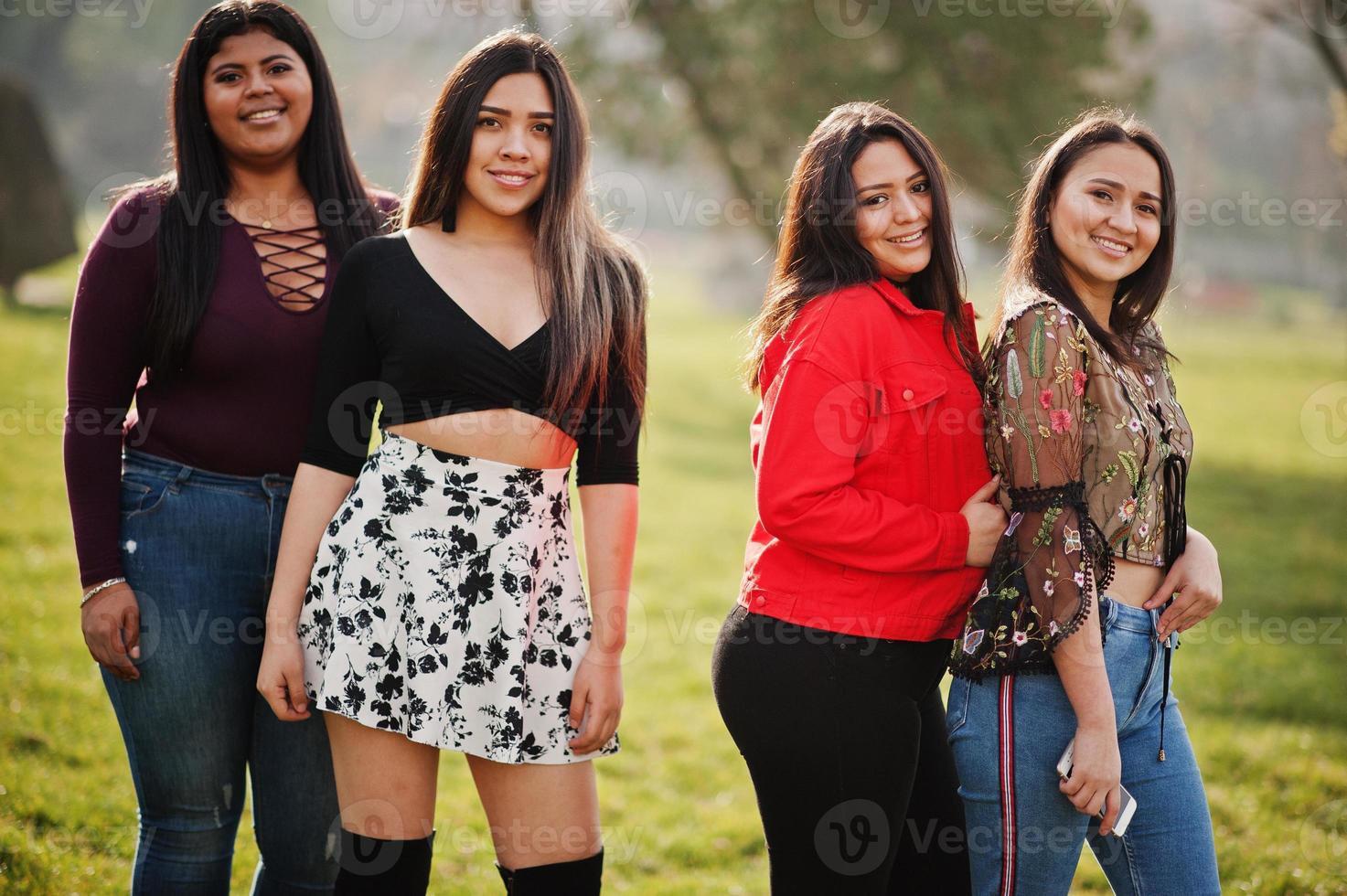 groep van vier gelukkige en mooie latino-meisjes uit ecuador poseerden op straat. foto