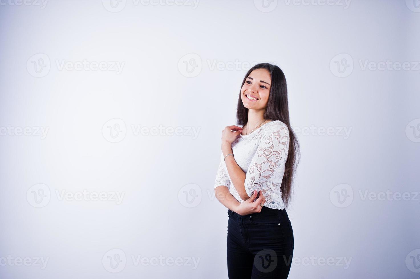 portret van een elegante jonge vrouw in witte top en zwarte broek in de studio. foto