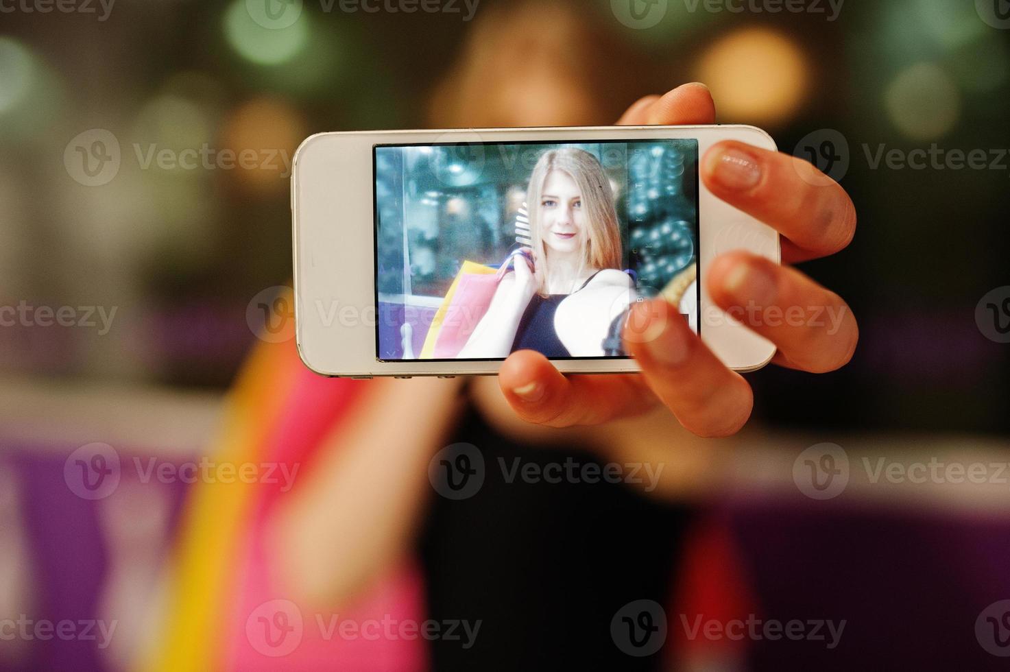 meisje met boodschappentassen op het scherm aan de telefoon. foto