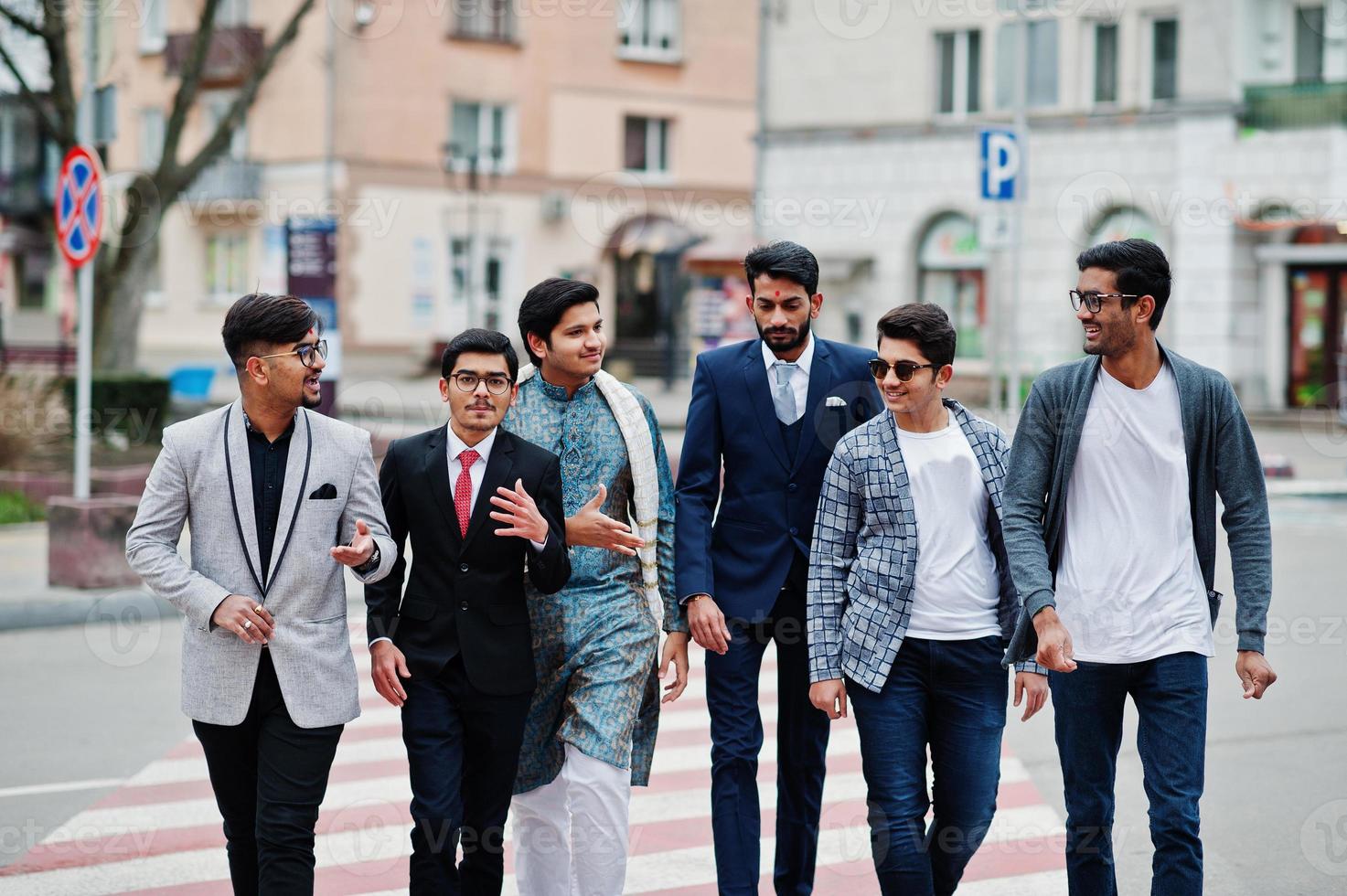 groep van zes Zuid-Aziatische indiaan mans in traditionele, casual en zakelijke kleding die samen op zebrapad lopen. foto