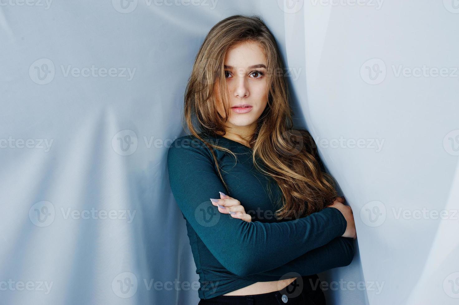 knappe brunette meisje slijtage op groen, poseren op gordijnen. studiomodel portret. foto