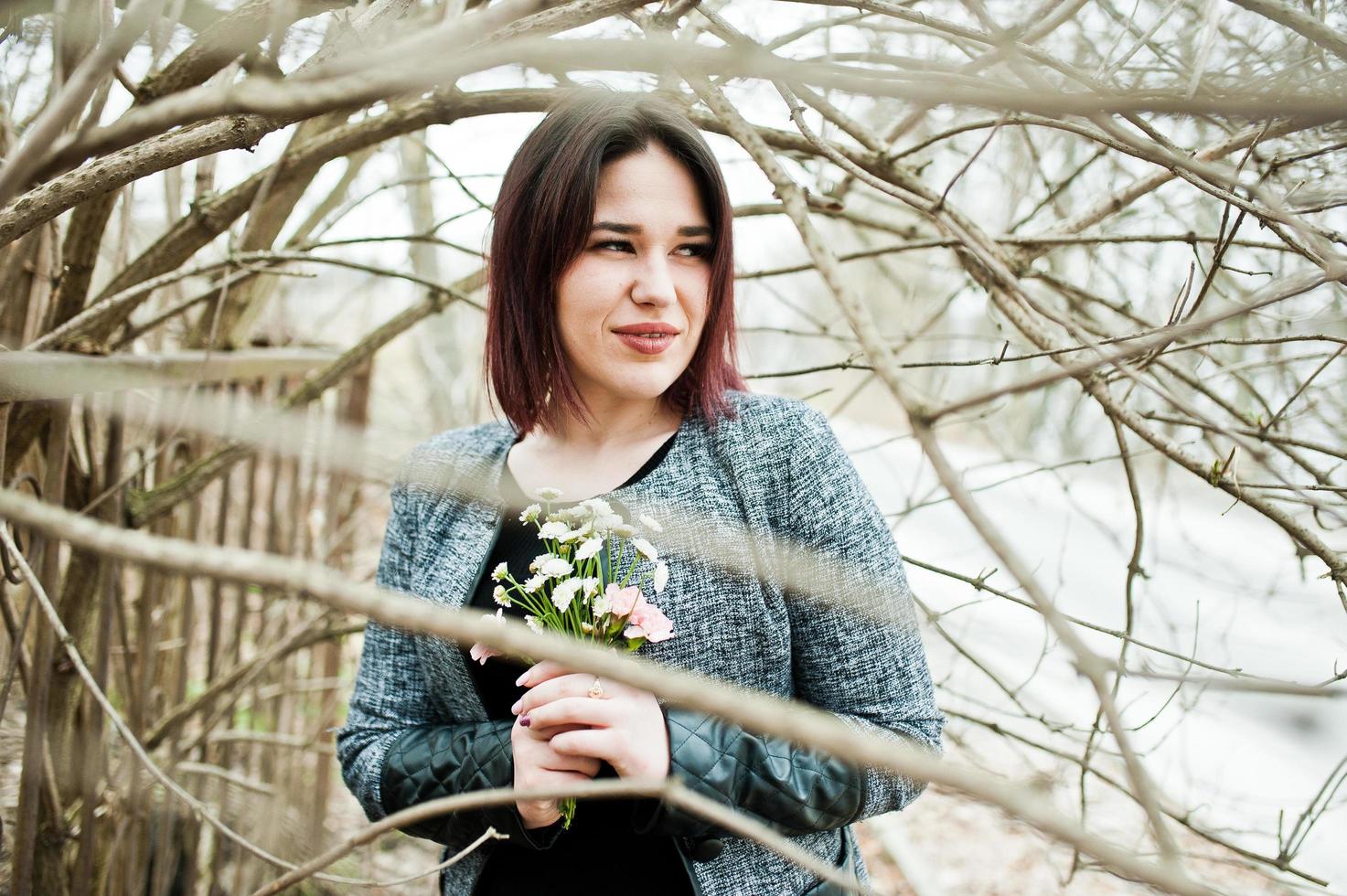 portret van brunette meisje in zwarte jurk op lente hout. foto