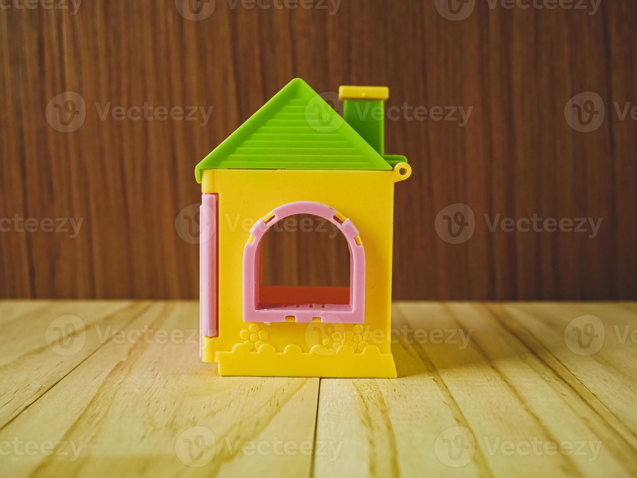 het huisspeelgoed op houten tafel voor eigendom en bouwinhoud. foto