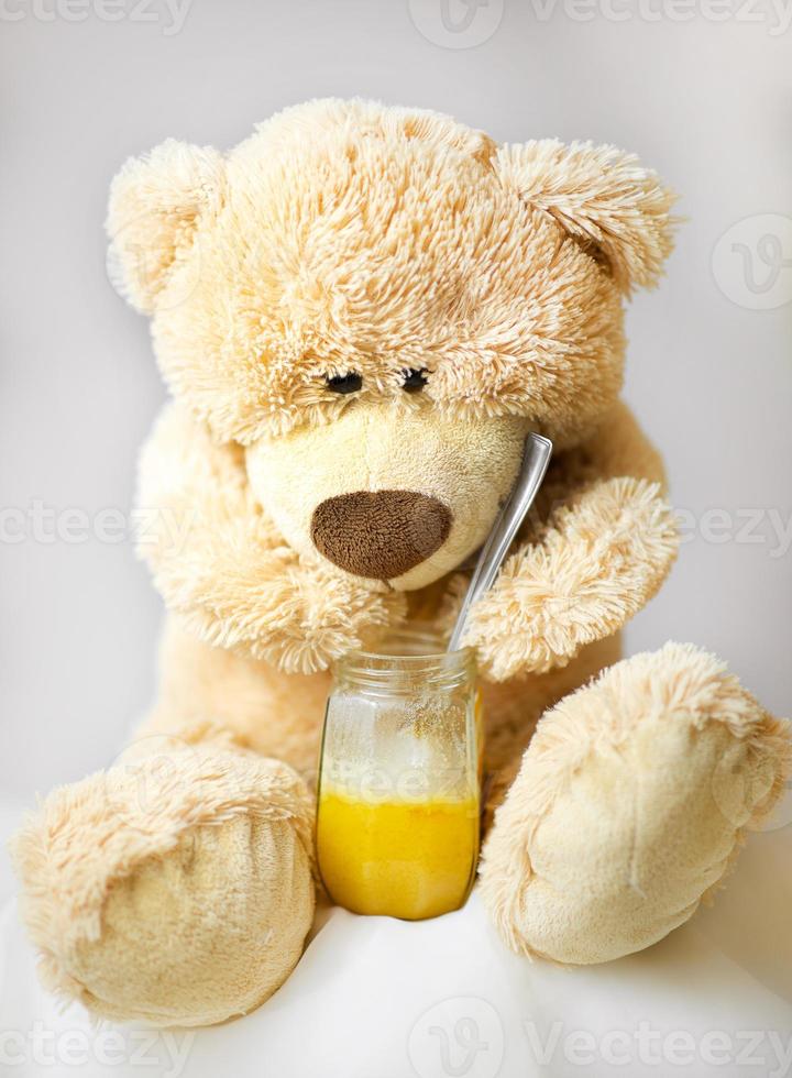 teddybeer zit en eet honing foto